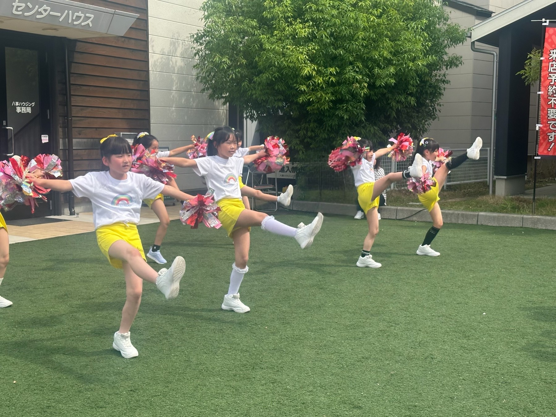 青空の下、芝生で演技を披露する子どもたち