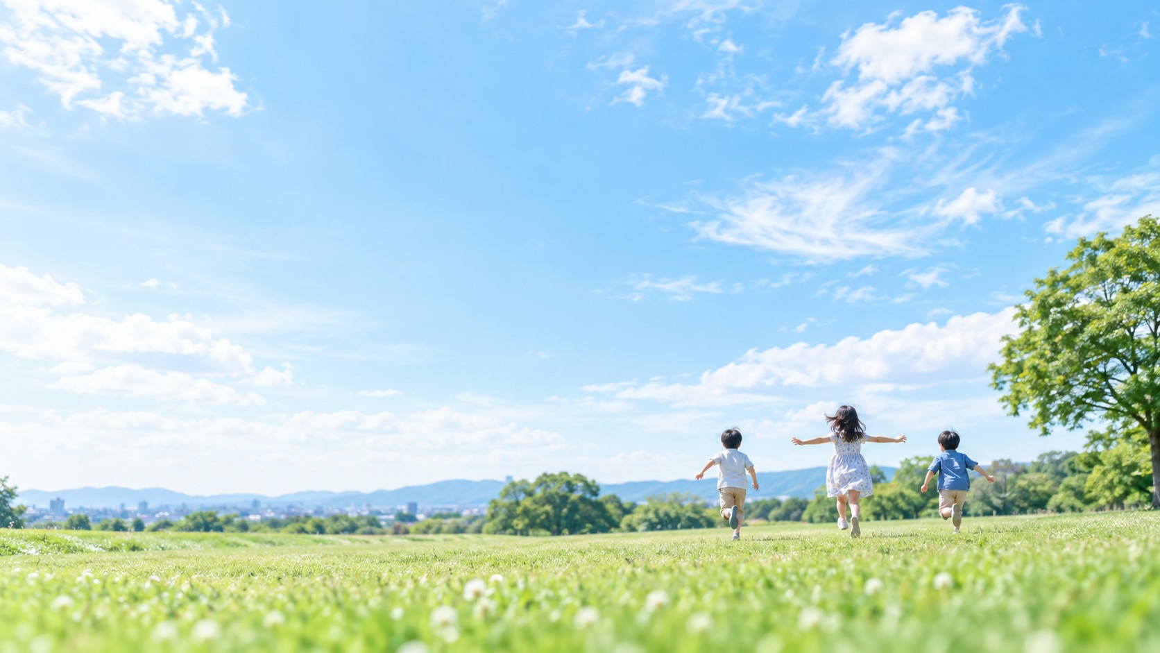 青空と草原に広がる、子どもたちの成長をイメージした風景